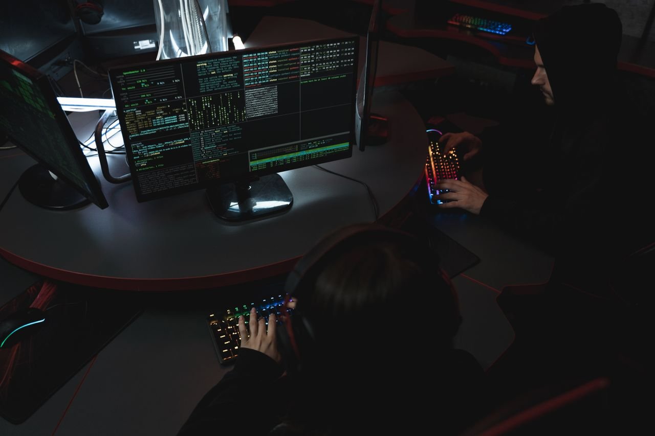 who-we-are A group of people in a dark room working on computers, related to cybersecurity.
